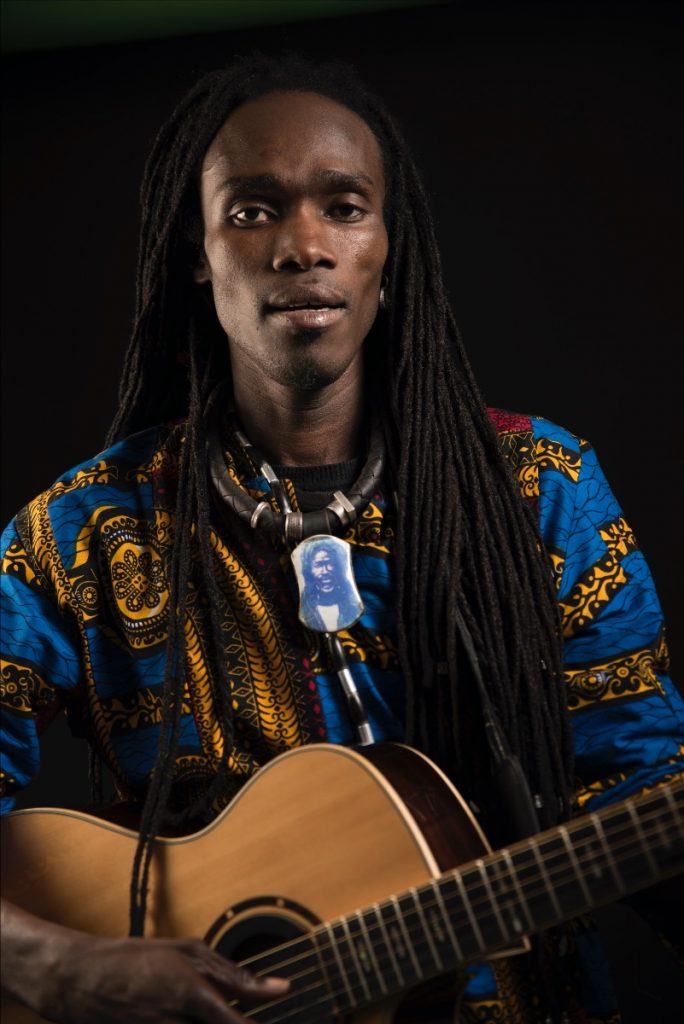 Nyumbani, Episode 6 headlined by West African Griot, Batch Gueye Batch Gruye holding a guitar in traditional African clothing.