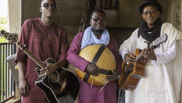 Afel Bocoum posing with his bandmates all holding instruments